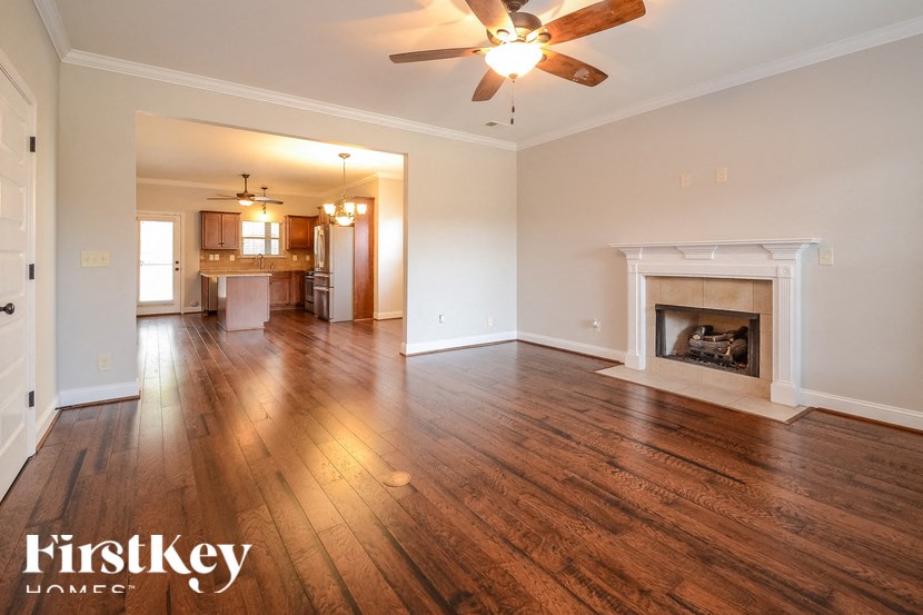 A spacious living room with wood flooring and a fireplace.