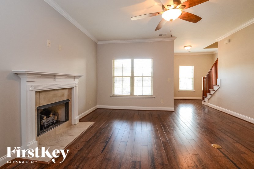 A spacious room with a fireplace and wooden floors.