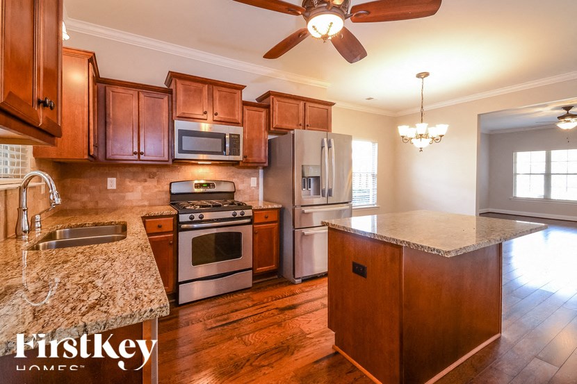A kitchen with wooden cabinets and a granite countertop.