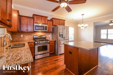 A kitchen with wooden cabinets and a granite countertop.