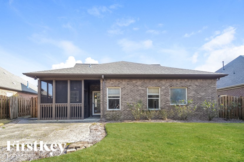 A house with a grey roof and a green lawn in front.