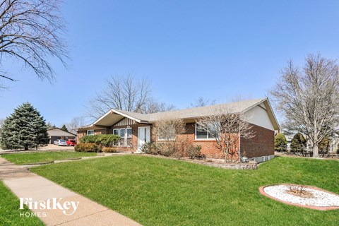 a home with a lawn and a sidewalk in front of it