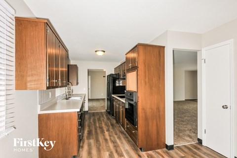 a kitchen with wooden cabinets and white counter tops and a black stove and refrigerator