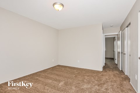 a master bedroom with a carpeted floor and white walls