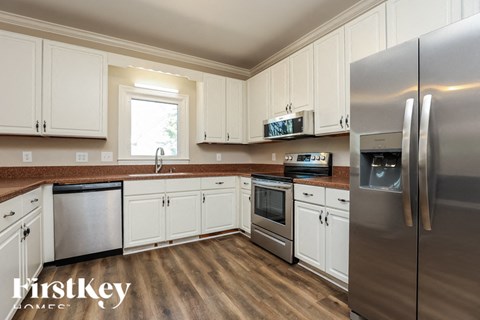 A kitchen with white cabinets and stainless steel appliances.