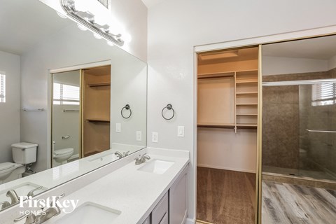 a bathroom with a large mirror and a sink and a shower