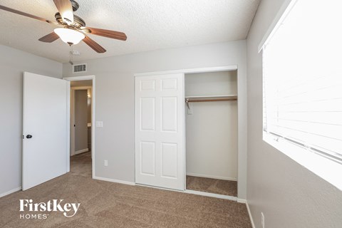 a bedroom with a ceiling fan and a closet