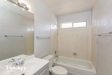 a white bathroom with a tub sink and toilet