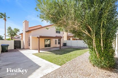 a house with a tree in the yard and a driveway