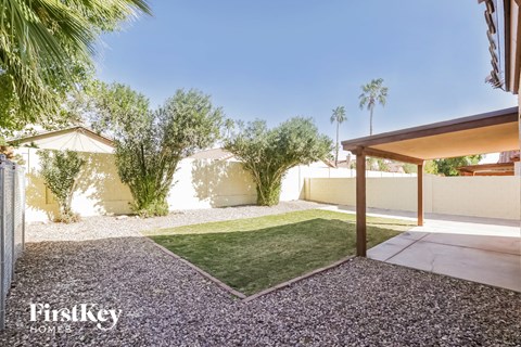 a backyard with grass and trees and a patio