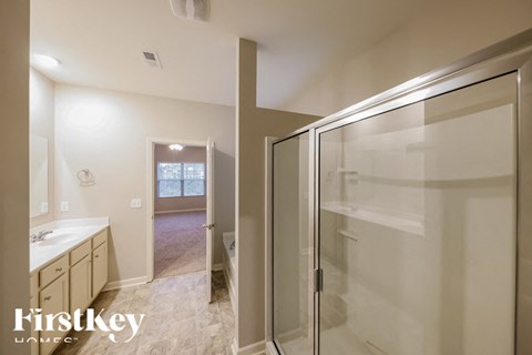 A kitchen with a white counter top and a glass door cabinet.