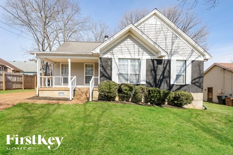 A house with a well-maintained lawn and a clear sky in the background.