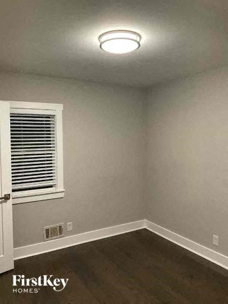 an empty room with a window and a white lamp on the ceiling
