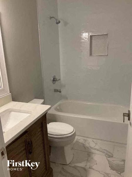 a bathroom with a toilet and a tub and a sink