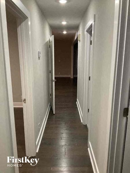a hallway with white walls and a wood floor