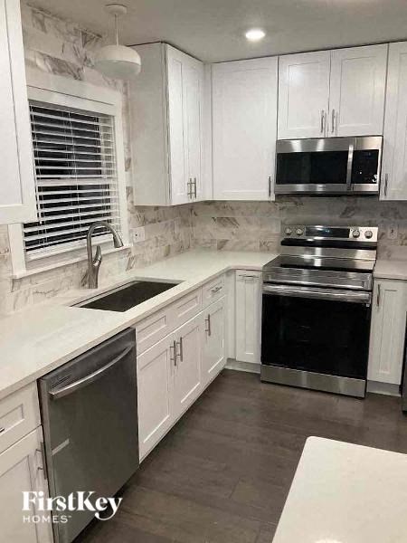 a kitchen with white cabinets and a stove and a microwave