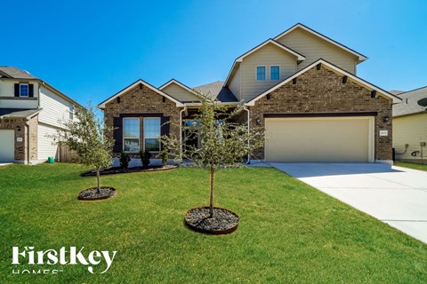 a front yard with two trees in front of a house