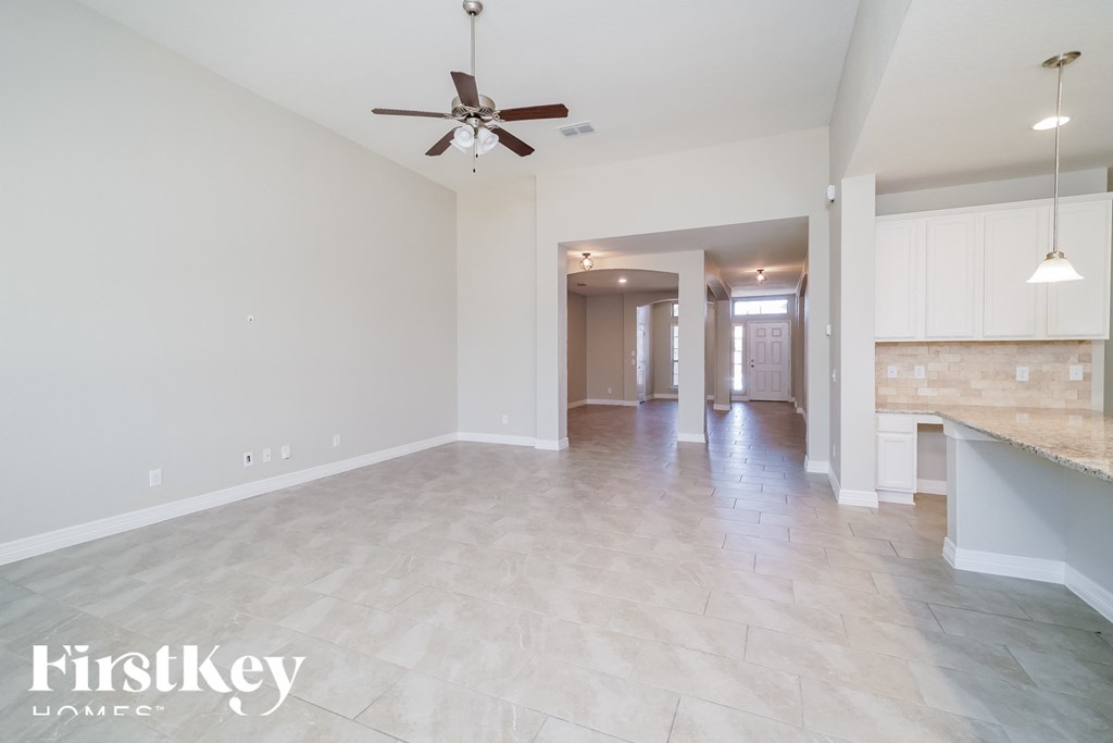 an empty kitchen and living room with a ceiling fan