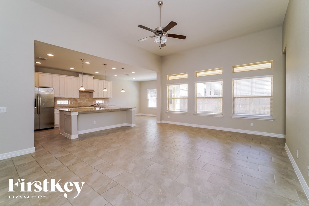 an empty kitchen and living room with a ceiling fan