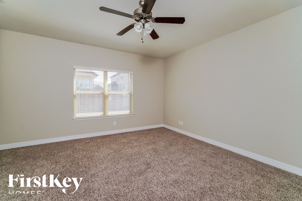 a bedroom with carpet and a ceiling fan