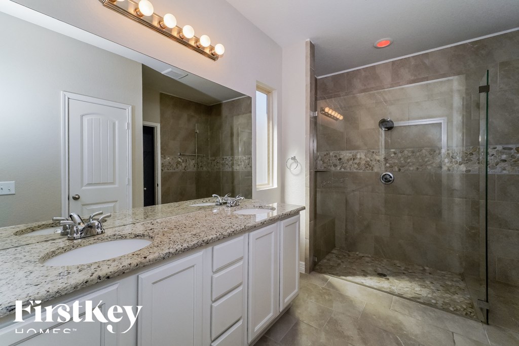 a bathroom with two sinks and a large shower