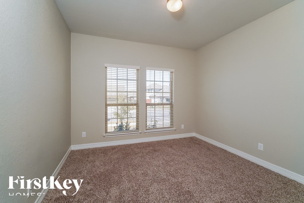 a bedroom with a carpeted floor and two windows