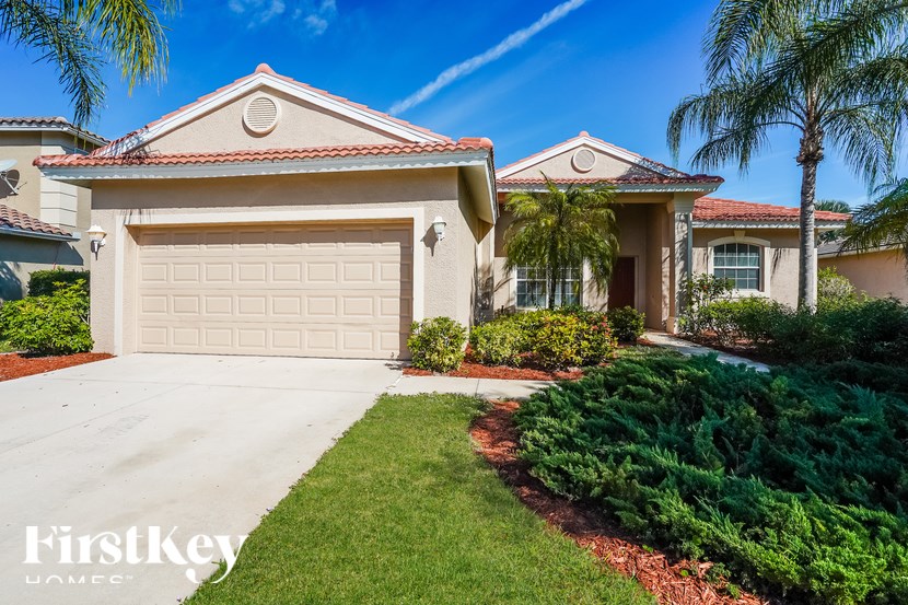 A house with a garage and a driveway in front of it.