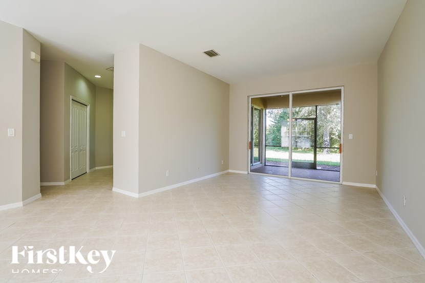 A spacious room with a sliding glass door leading to a backyard.