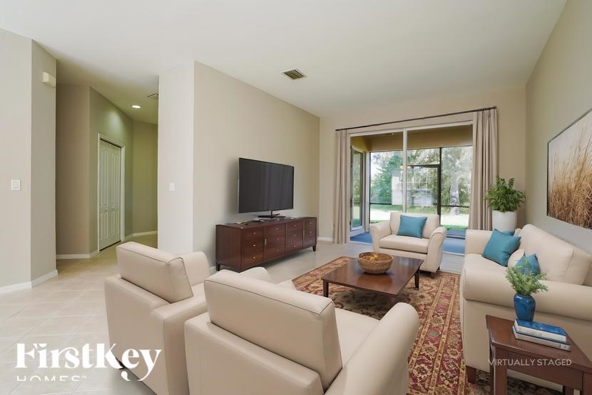 A living room with a flat screen TV and a large window.