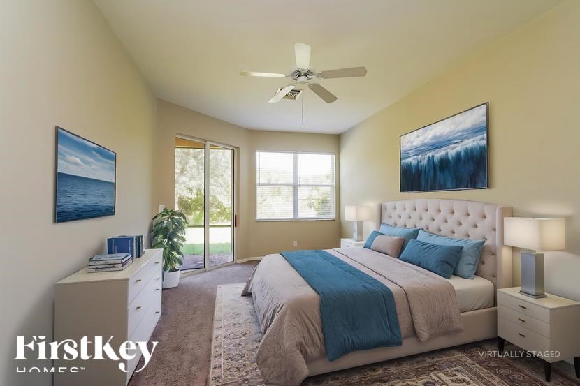 A bedroom with a large bed and a ceiling fan.