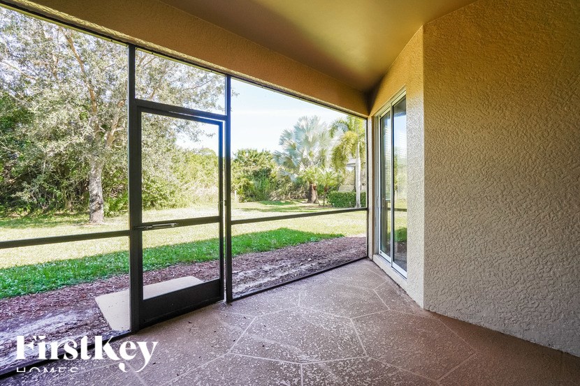A patio with a sliding glass door opens to a grassy area.