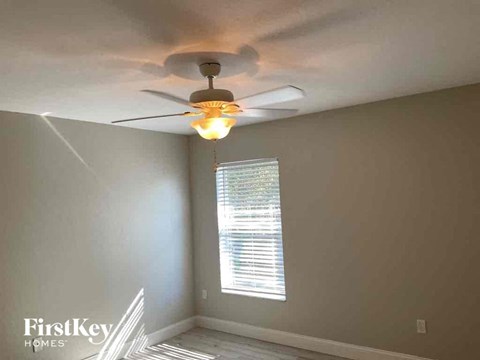 a bedroom with a ceiling fan and a window