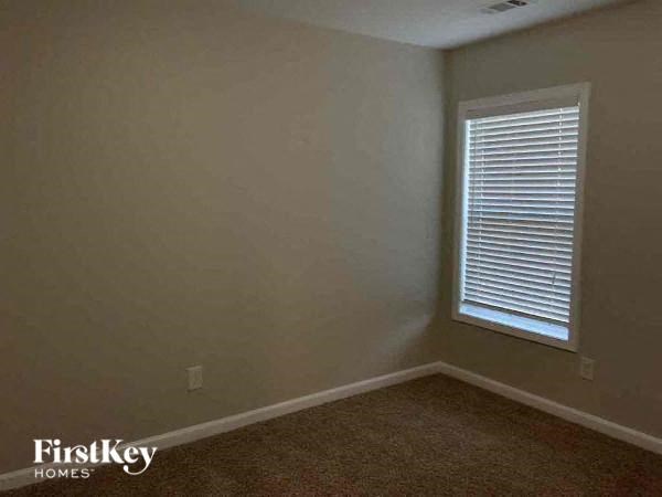 an empty room with a window and a carpet