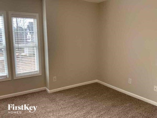 an empty room with a window and a carpeted floor