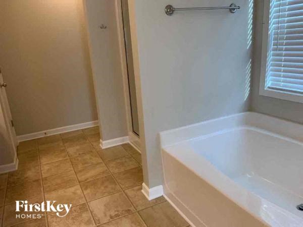 a bathroom with a tub and a shower and a window
