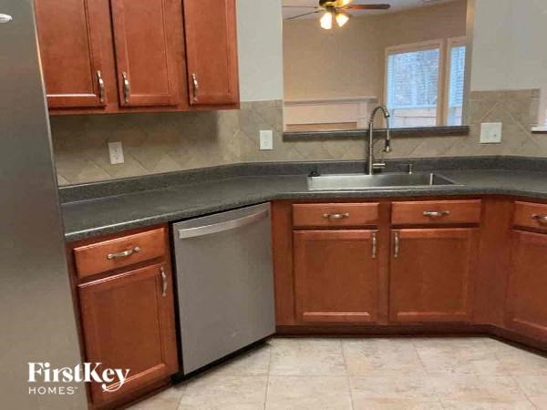 a kitchen with wooden cabinets and a stainless steel sink