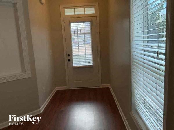a hallway with a white door and wood floors