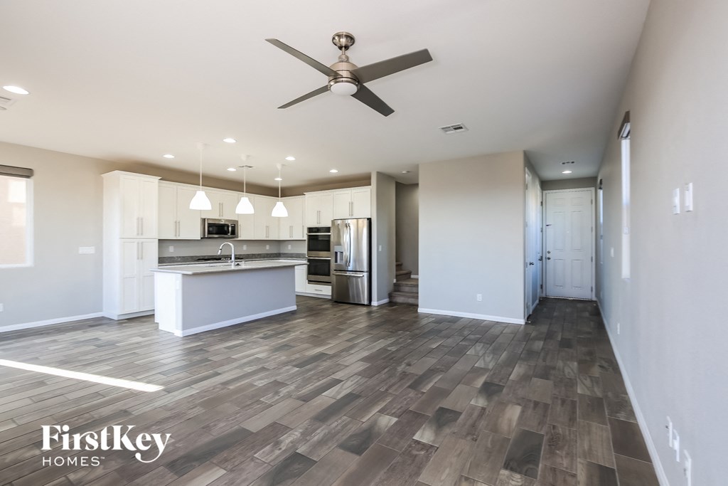 an open kitchen and living room with a ceiling fan