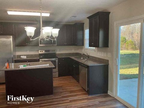 a kitchen with black cabinets and a large window