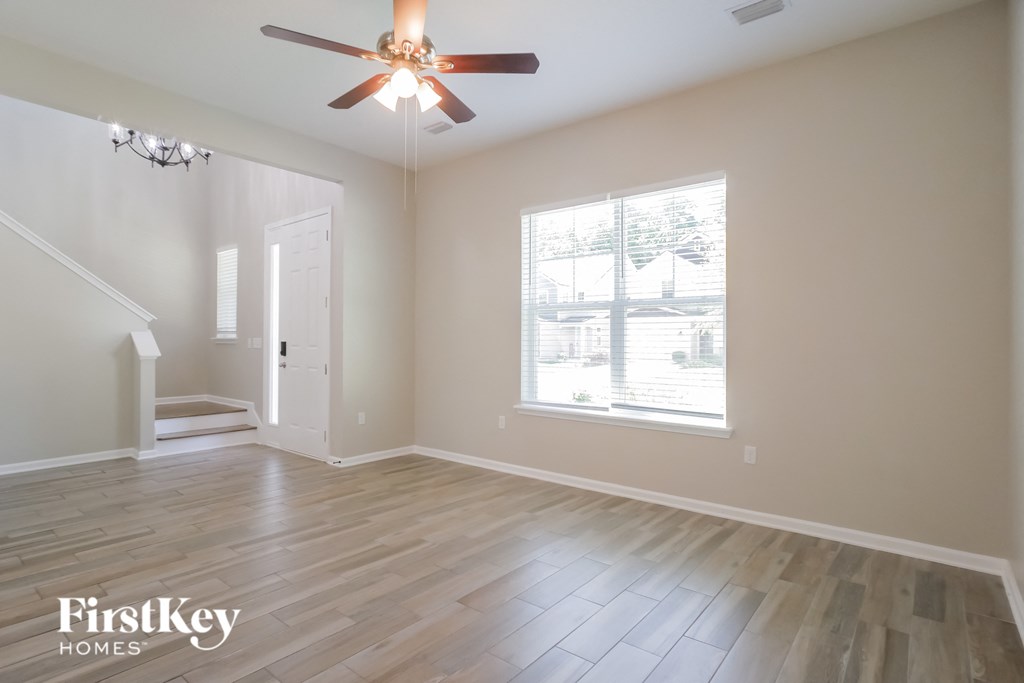 A room with a ceiling fan and wooden flooring.
