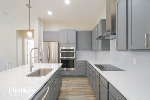 A modern kitchen with a stainless steel refrigerator and oven.