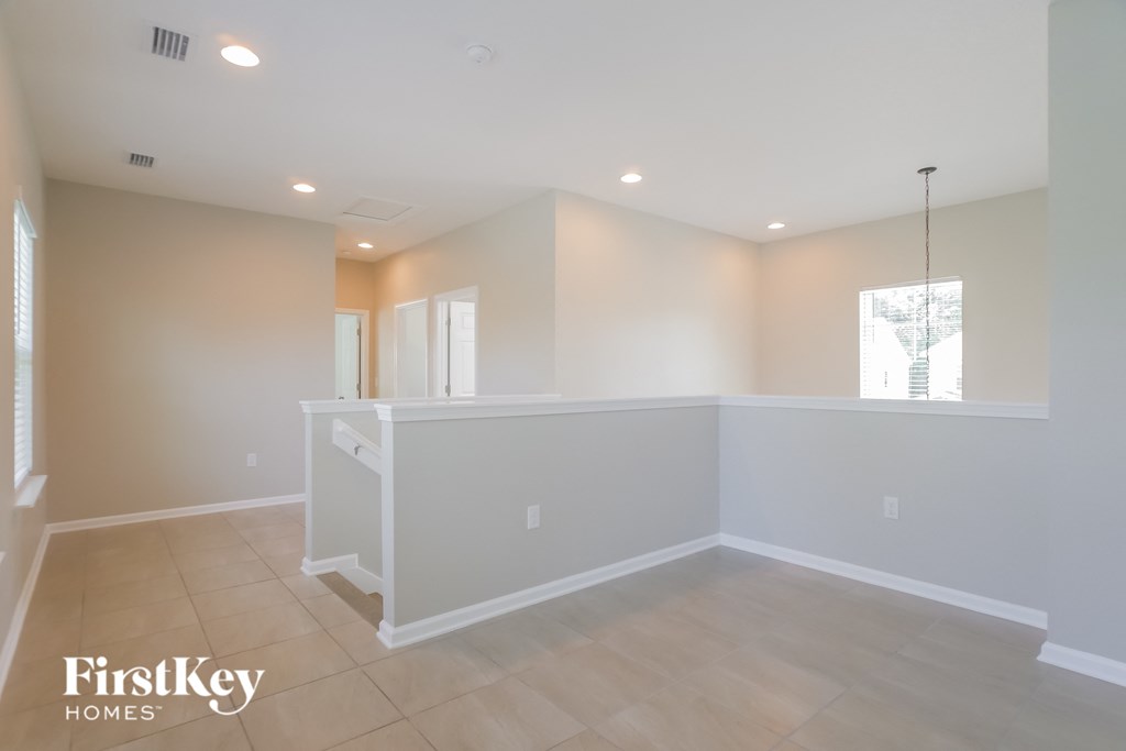A spacious room with a white reception desk and a hanging light fixture.