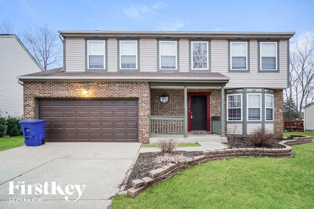 A house with a brown garage door and a red front door.