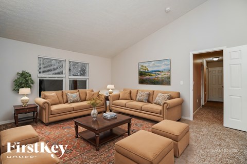 A living room with a couch, end tables, and a painting on the wall.