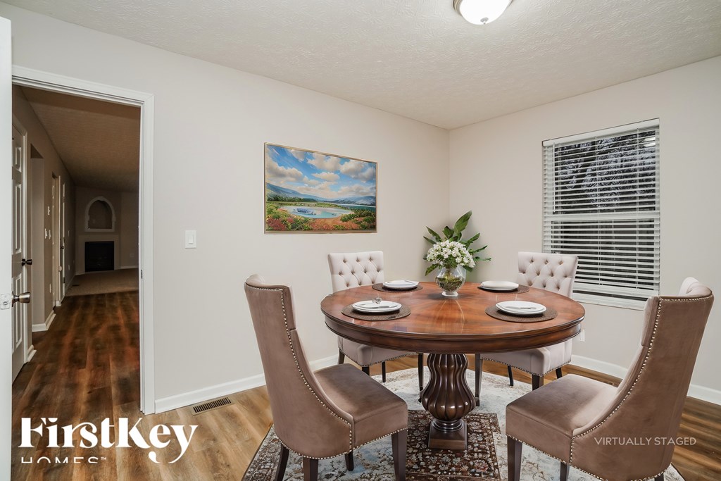 A dining room with a wooden table and chairs.