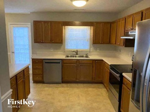 A kitchen with wooden cabinets and a stainless steel refrigerator.