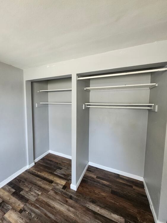A room with a grey wall and a wooden floor.