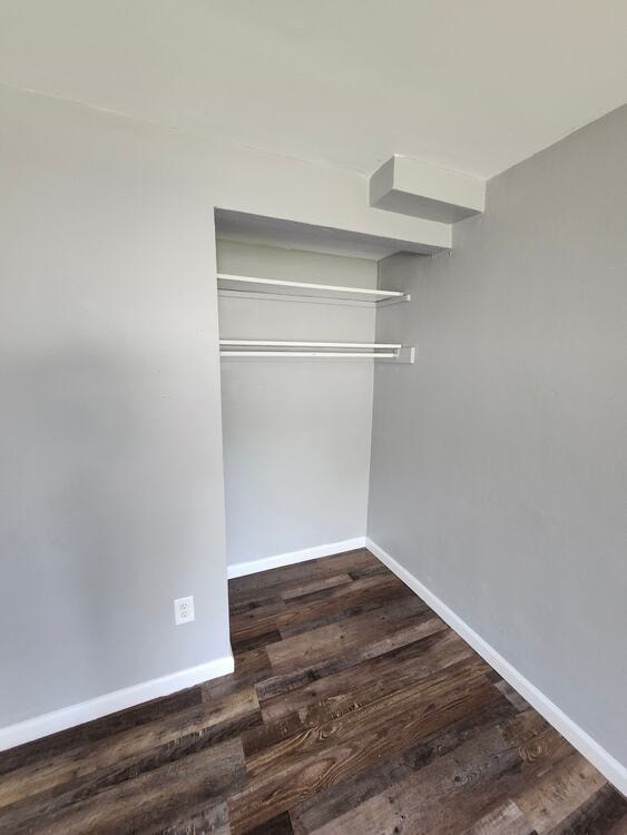 A room with a white wall and a wooden floor.