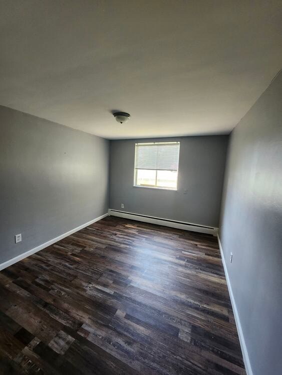 A room with a window and wooden flooring.