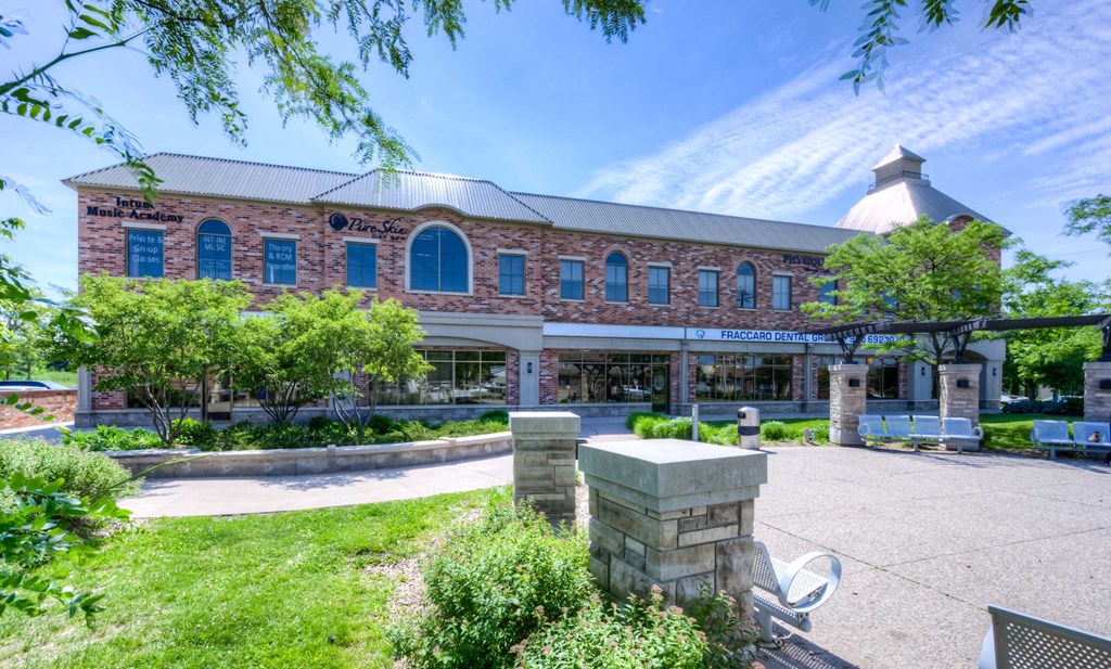 a large brick building with trees and grass in front of it